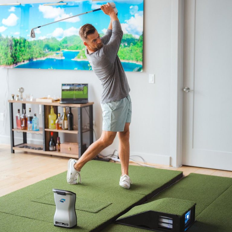 golfer finishing swing with GCQuad launch monitor on SIGPRO Softy 4x10 golf mat